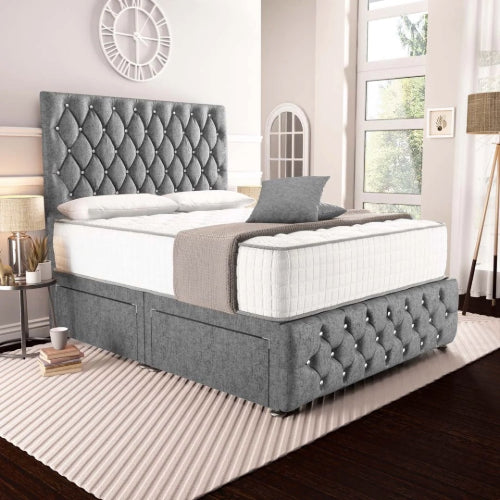 Gray tufted bed with white mattress in a bedroom setting